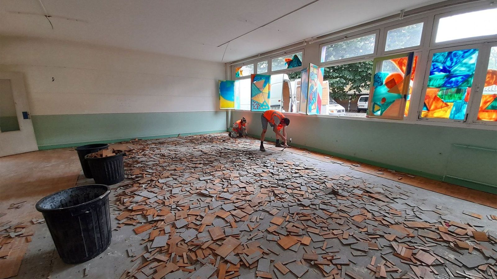 Photo d'ouvriers récupérant les matériaux au sol lors de la déconstruction d'une friche urbaine